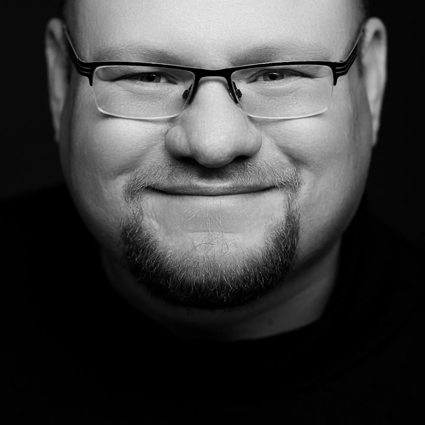 Schwarz-Weiß-Porträt von Hans-Martin Hörtling, lächelnd, mit Brille