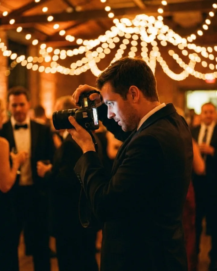 Eventfotograf prüft seine Aufnahmen auf einer Abendveranstaltung (KI-generiertes Bild)