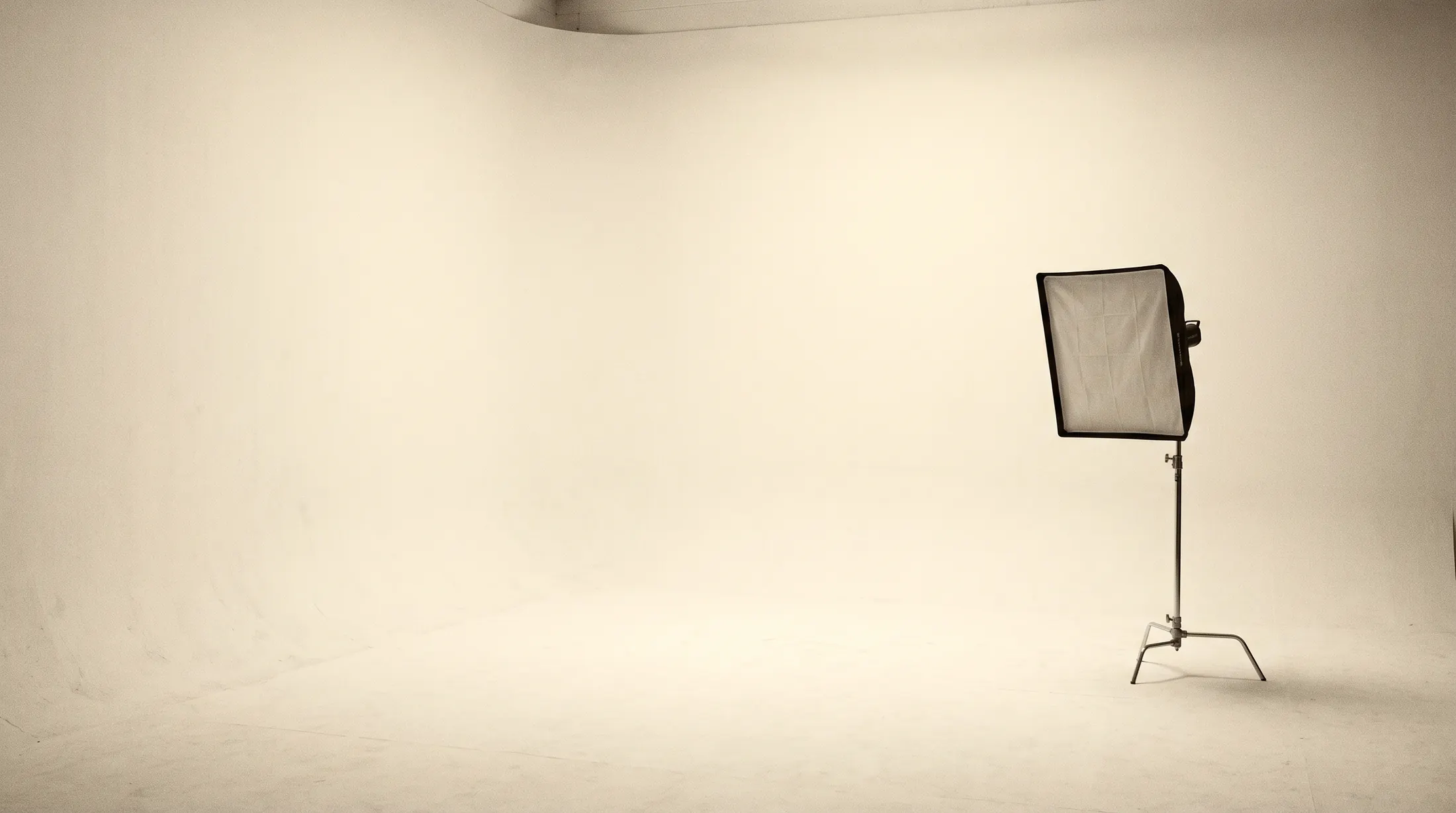 Eine einzelne Studioleuchte mit Softbox in einem leeren hellen Fotostudio